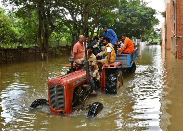 FILE PHOTO: Residents are evacuated to safer places in a tractor trolley after heavy rains caused flooding in a residential area in Bengaluru