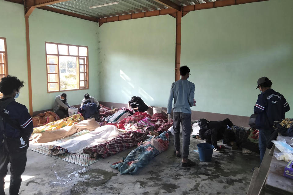 People clean the victims of airstrikes being shrouded in blankets at a building in Kanan village, Khampat town in Sagaing region on Sunday, Jan.7, 2024. Airstrikes by Myanmar’s military on a village under the control of the pro-democracy resistance in the country’s northwest are reported to have killed at least 17 civilians, including nine children. (AP Photo)