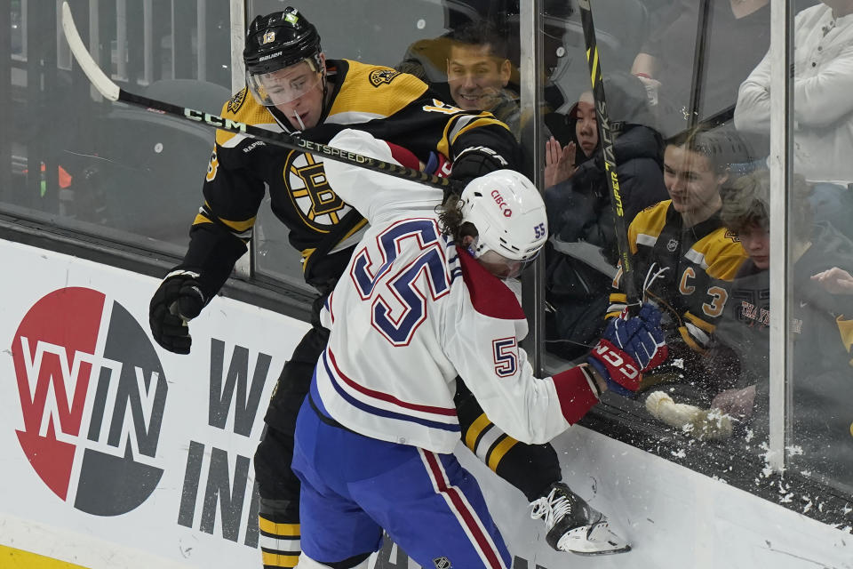 Boston Bruins center Charlie Coyle and Montreal Canadiens left wing Michael Pezzetta (55) slam into the boards after colliding during the first period of an NHL hockey game, Thursday, March 23, 2023, in Boston. (AP Photo/Steven Senne)