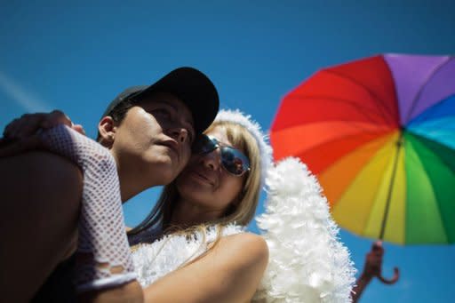 A gay couple poses during the gay pride parade at Copacabana beach in Rio de Janeiro, Brazil. Techno music was thumping as tens of thousands hit the streets in Rio Sunday for the annual Gay Pride Parade, which organizers insisted was both a party and political