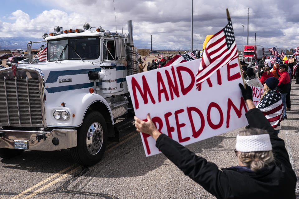 Supporters cheer on the beginning of a trucker caravan to Washington, D.C., called The People's Convoy on Wednesday, Feb. 23, 2022, in Adelanto, Calif. A small convoy of truckers demanding an end to coronavirus mandates began a cross-country drive from California to the Washington, D.C., area on Wednesday. (AP Photo/Nathan Howard)