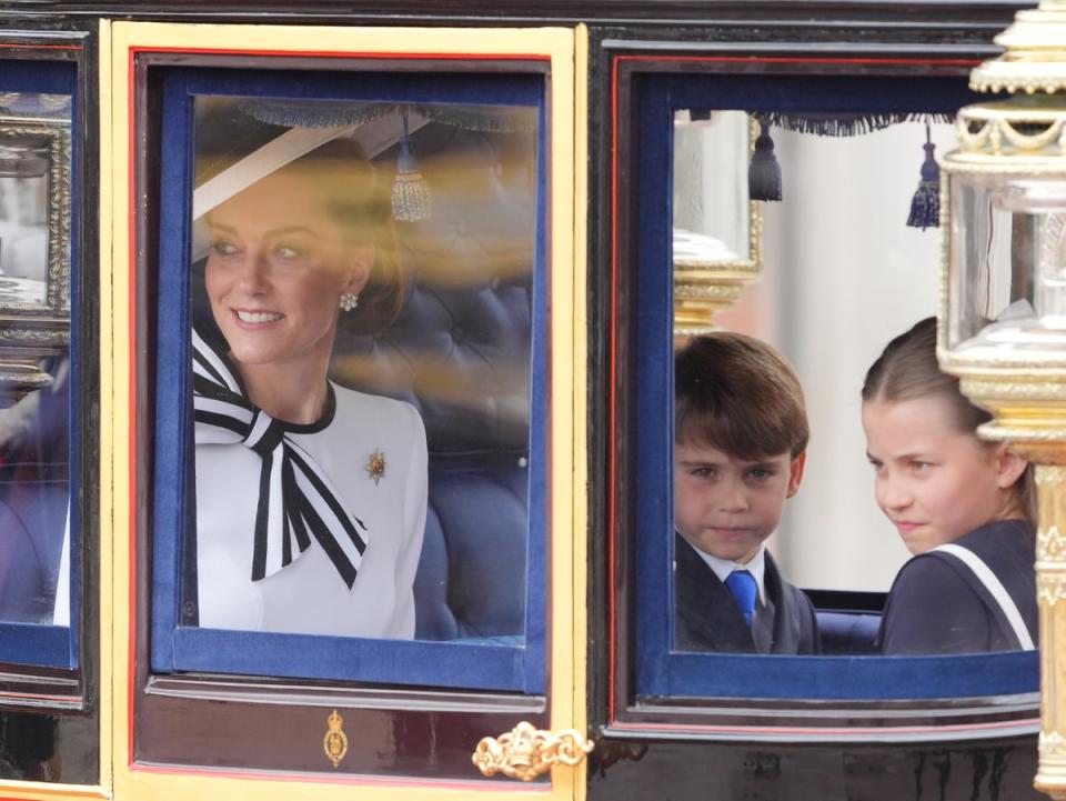 Prince Louis and Princess Charlotte look out at the crowds while their mother smiles and waves (Jonathan Brady/PA Wire)