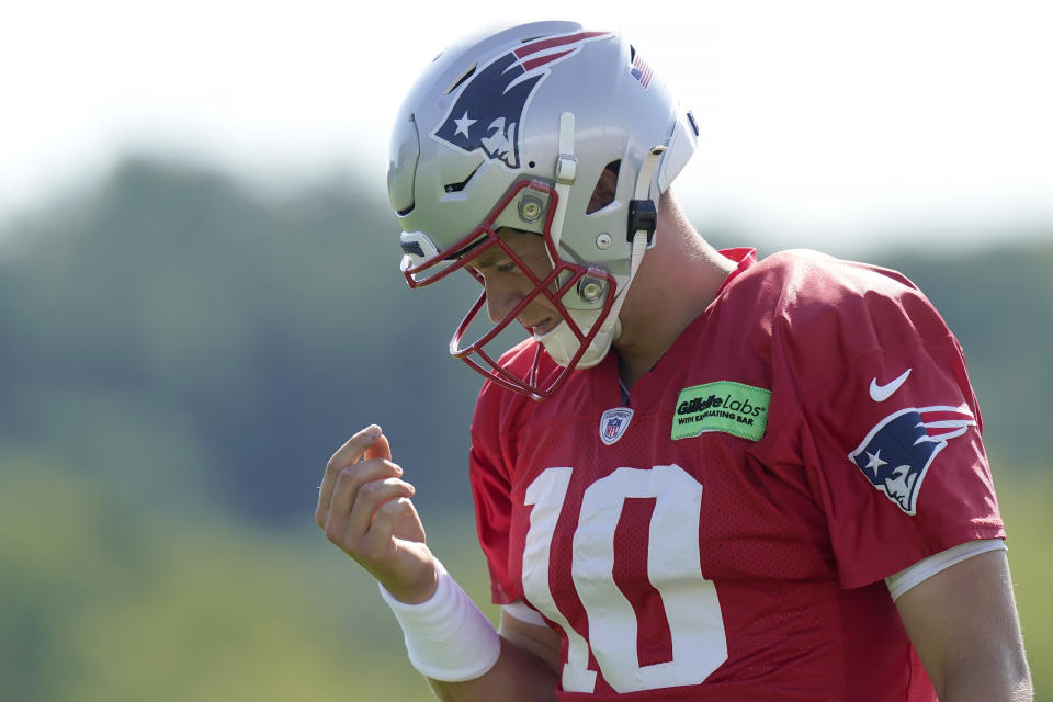 New England Patriots quarterback Mac Jones (10) looks toward his hand during the NFL football team's training camp, Wednesday, Aug. 3, 2022, in Foxborough, Mass. (AP Photo/Steven Senne)