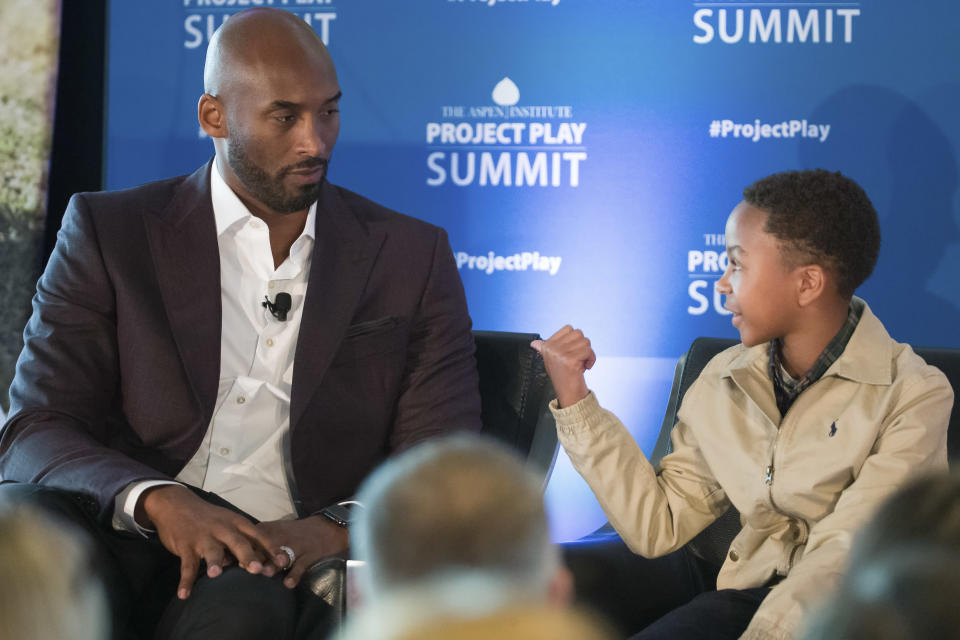 Former NBA basketball all-star Kobe Bryant, left, listens to Owen Norwood, 11, from Mobile, Ala., as he moderates a panel about youth sports during the Aspen Institute's Project Play Summit, Tuesday, Oct. 16, 2018 in Washington. (AP Photo/Alex Brandon)