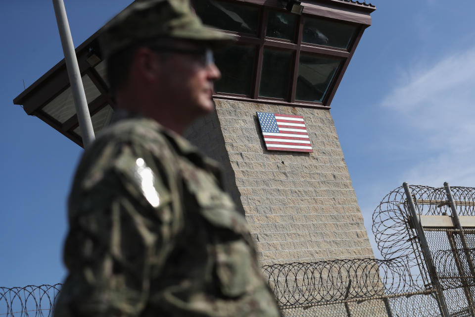 A U.S. Naval officer stands at the entrance of the prison at Guantánamo Bay.