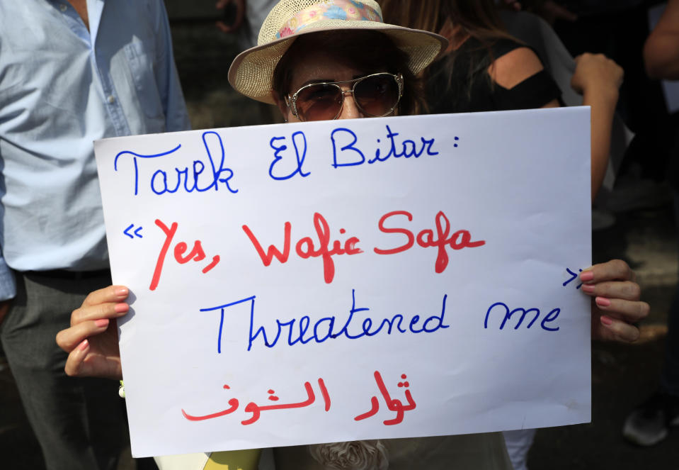A protester holds a placard outside a court building during a demonstration of solidarity with Judge Tarek Bitar who is investigating last year's deadly seaport blast, in Beirut, Lebanon, Wednesday, Sept. 29, 2021. Hundreds of Lebanese, including families of the Beirut port explosion victims, rallied Wednesday outside the court of justice in support of Bitar after he was forced to suspend his work. Bitar is the second judge to take on the complicated investigation. (AP Photo/Hussein Malla)