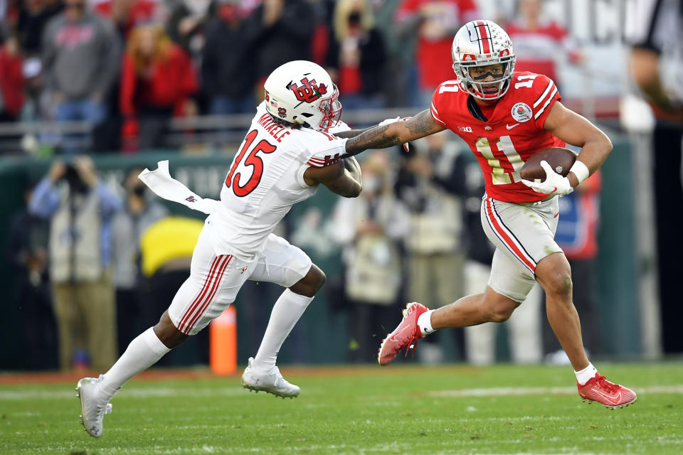 FILE - Ohio State wide receiver Jaxon Smith-Njigba runs next to Utah cornerback Malone Mataele (15) during the first half in the Rose Bowl NCAA college football game Saturday, Jan. 1, 2022, in Pasadena, Calif. Smith-Njigba was selected to The Associated Press preseason All-America team, Monday, Aug. 22, 2022. (AP Photo/John McCoy, File)