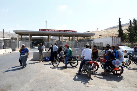 People wait in front of the Turkish Cilvegozu border gate, located opposite the Syrian commercial crossing point Bab al-Hawa, in Reyhanli, Hatay province, Turkey, September 15, 2016. REUTERS/Osman Orsal