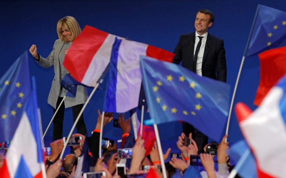 Emmanuel Macron arrives on stage with his wife Brigitte Trogneux to deliver a speech at the Parc des Expositions hall in Paris  - Credit:  PHILIPPE WOJAZER/REUTERS