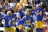 Players on the sideline celebrate as Pittsburgh's M.J. Devonshire (12) returns a punt for a touchdown during the first half of an NCAA college football game against Rhode Island, Saturday, Sept. 24, 2022, in Pittsburgh. (AP Photo/Keith Srakocic)