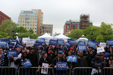 People hold up campaign signs as Democratic 2020 U.S presidential candidate Andrew Yang holds a rally in the Manhattan borough of New York, May 14, 2019. REUTERS/Gabriela Bhaskar