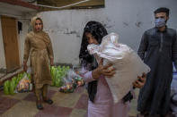 Bilal Ahmed, a transgender Kashmiri, carries a bag of rice distributed as food handout by a group in Srinagar, Indian controlled Kashmir, Thursday, May 27, 2021. Life has not been easy for many of Kashmir's transgender people. Most are ostracized by families and bullied in society. Living in the shadows of conflict, coupled with the recent crisis of the pandemic, pushed the community further to the margins. (AP Photo/ Dar Yasin)