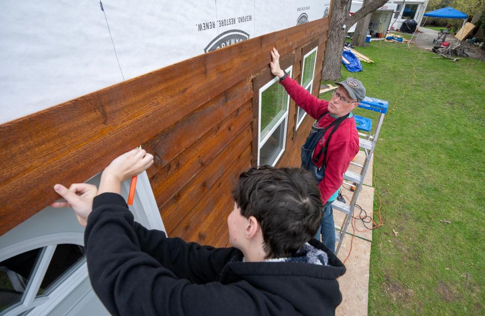 Adjunct instructor Jim Salinsky and students attach siding to the tiny house being built at Milwaukee Jewish Day School in Whitefish Bay. Salinsky wanted to give his students real world experience.
