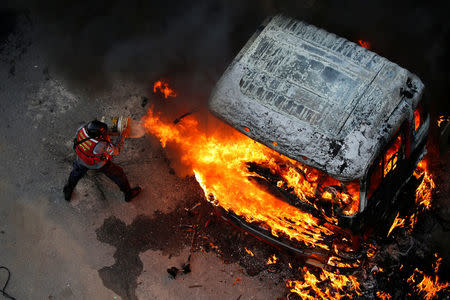 A fireman tries to extinguish a fire during a rally against Venezuela's President Nicolas Maduro in Caracas, Venezuela April 24, 2017. REUTERS/Carlos Garcia Rawlins