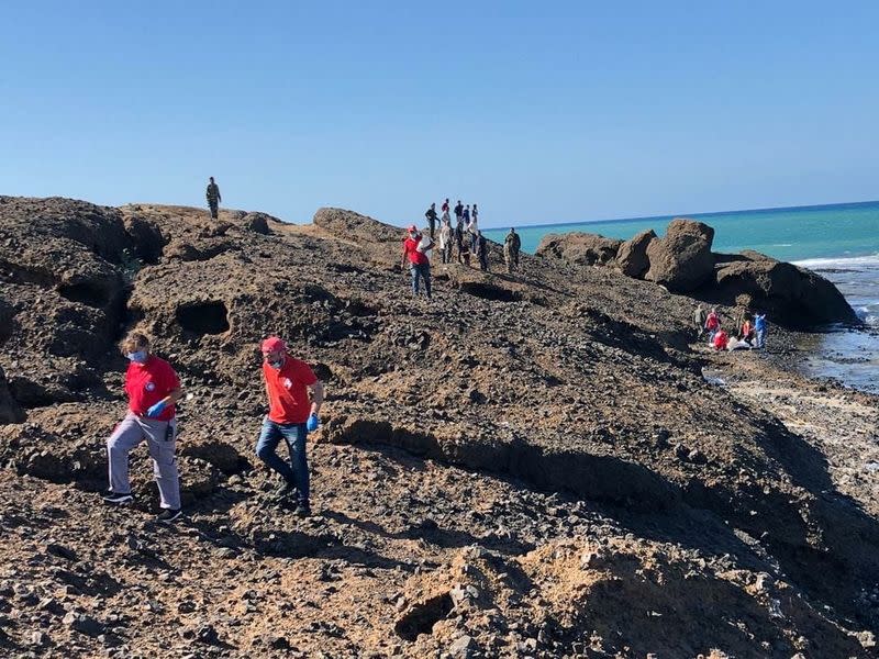 Members of Syrian Red Crescent walk by a shoreline in Tartous