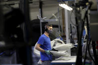 A worker assembles parts for hospital beds, at the Linet factory in Slany, Czech Republic, Monday, Oct. 19, 2020. A Czech hospital bed maker with a full order book received one more order that was impossible to turn down. The company was approached by Prime Minister Andrej Babis to deliver beds for a military field hospital for 500 COVID-19 patients, to be built this week in Prague. (AP Photo/Petr David Josek)