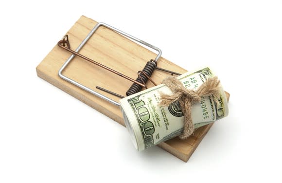 Roll of 100 dollar bills sitting on mouse trap