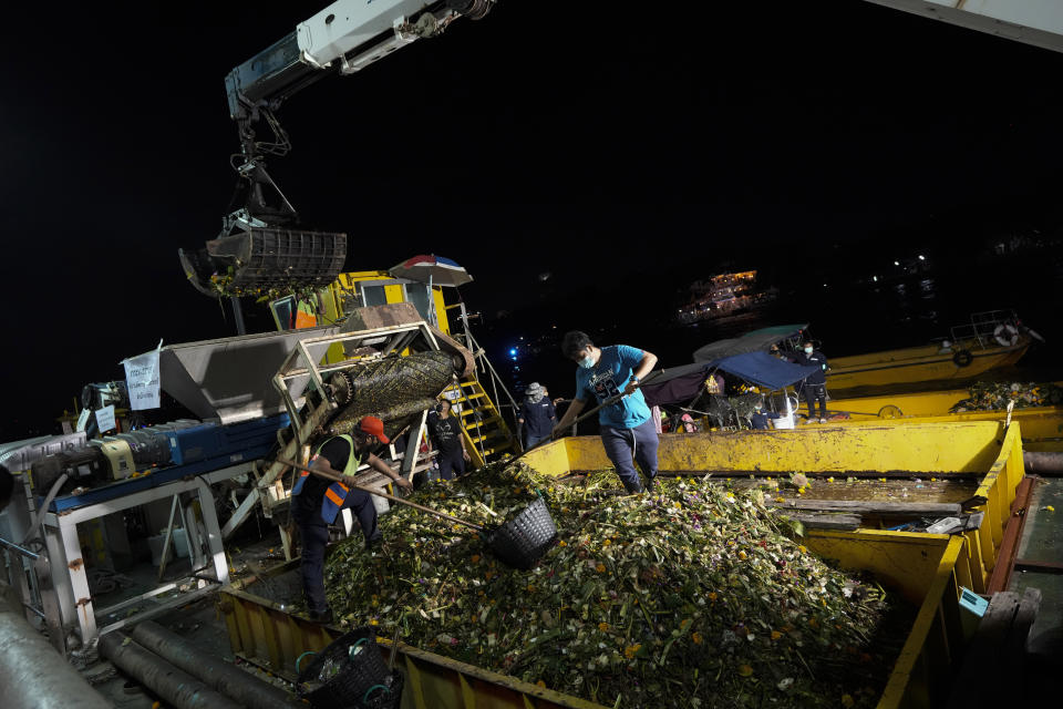 Workers collect small floating krathong from Chao Phraya River during Loy Krathong festival in Bangkok, Thailand, Friday, Nov. 19, 2021. As Thais flocked to waterways Friday to release small floats adorned with flowers and candles in an annual festival honoring the goddess of rivers, they also pile trash that clogs drains and canals and pollutes the country's rivers. (AP Photo/Sakchai Lalit)