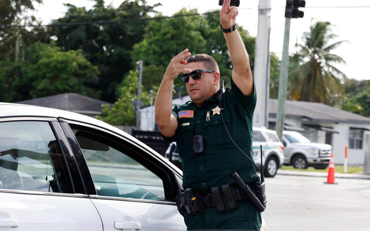 A police officer directs traffic near Trump International Golf Club