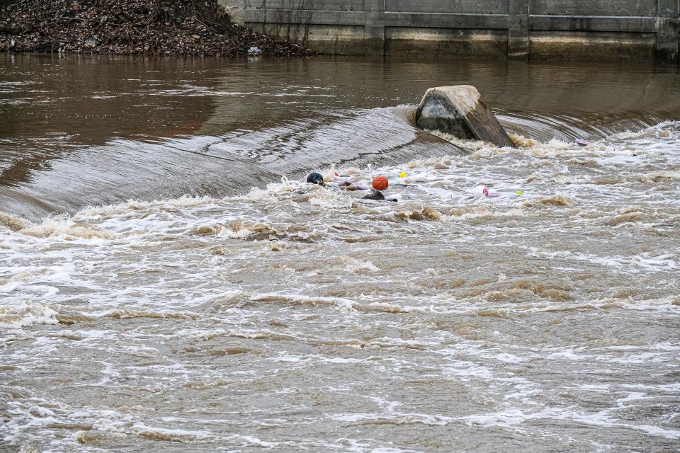 Debris is caught in the swirling water at the Grand River Dam in Lansing by the Brenke Fish Ladder Saturday, April 1, 2023. 