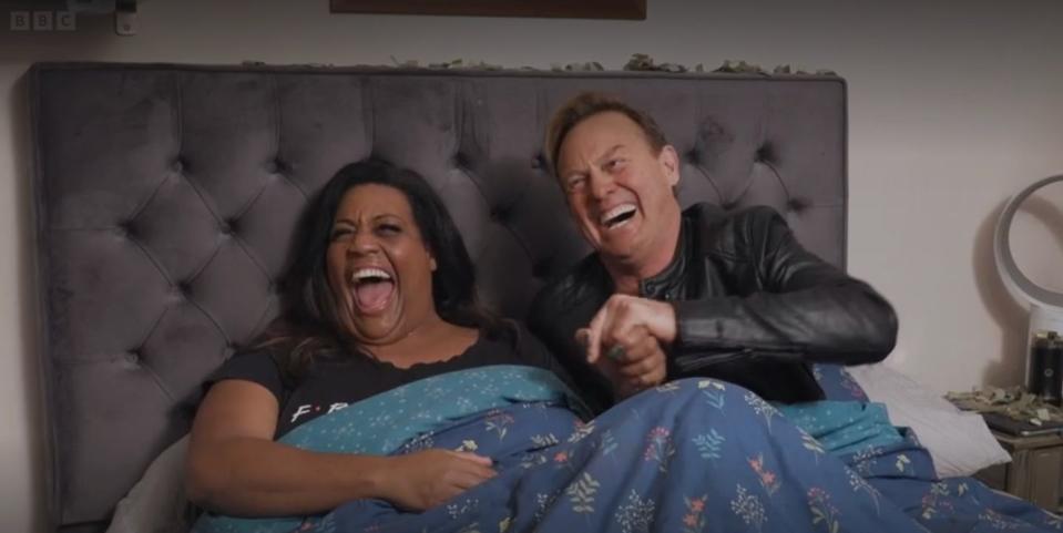 alison hammond and jason donovan sit in bed and laugh during a sketch on michael mcintyre's big show