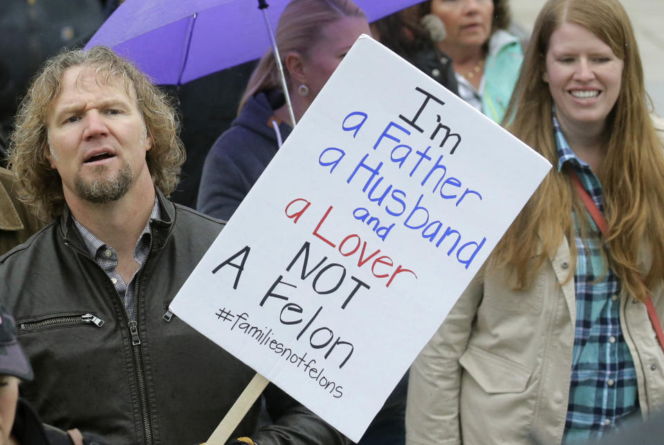 FILE - In this Feb. 10, 2017, file photo, Kody Brown, left, from "Sister Wives," a popular TV reality series about a polygamous family, marches during a protest at the state Capitol, in Salt Lake City. The recent slaying in Mexico of nine people who belonged to a Mormon offshoot community where some people practice polygamy shines a new spotlight on the ongoing struggle for the mainstream church to fight the association with plural marriage groups because of its past. (AP Photo/Rick Bowmer, File)