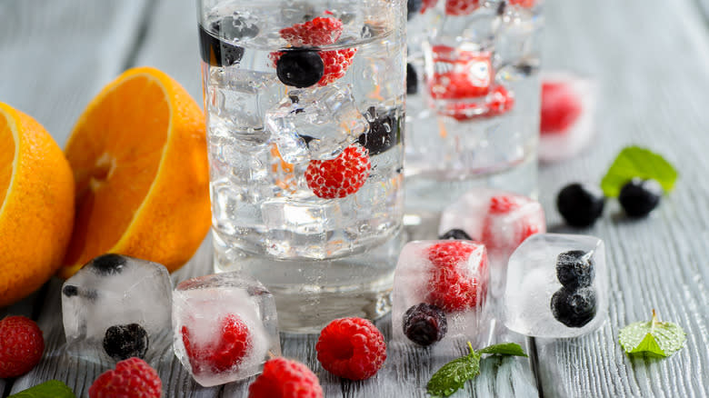 Drink with frozen berries in ice cubes 