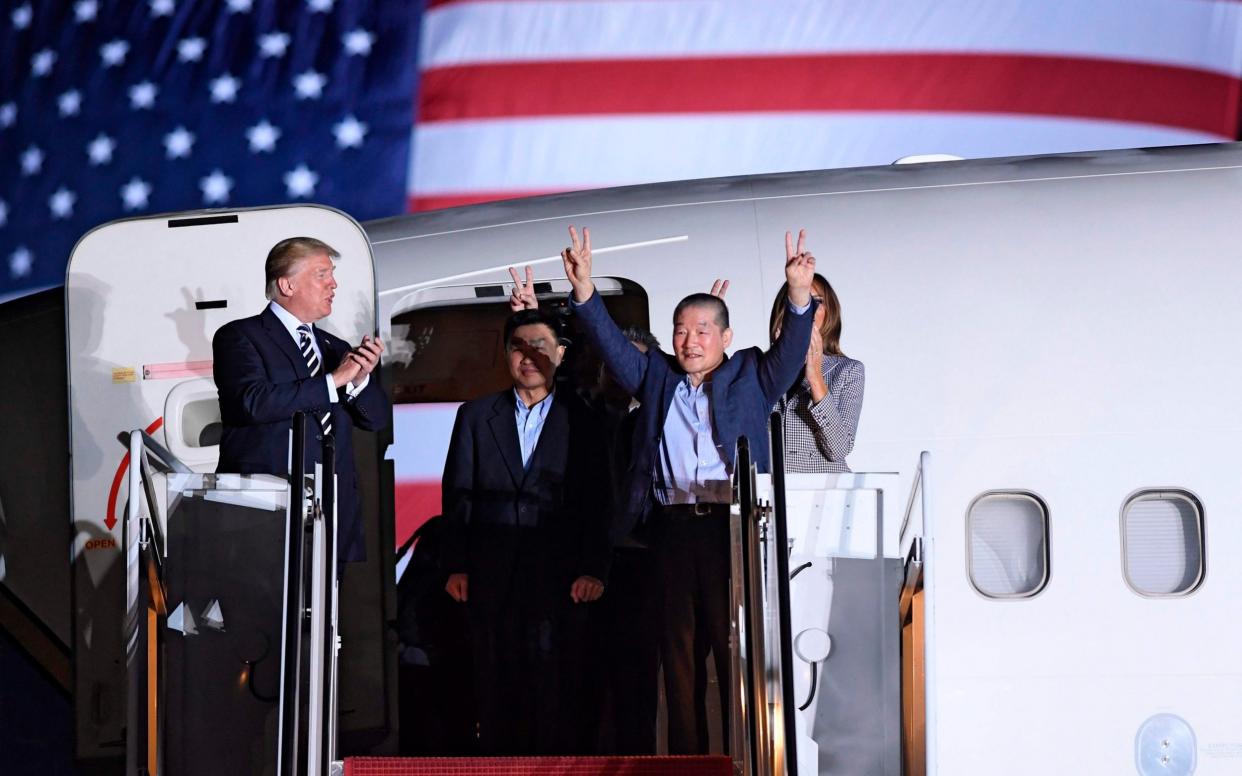 President Donald Trump applauds as the men emerge from the plane at Joint Base Andrews - AFP