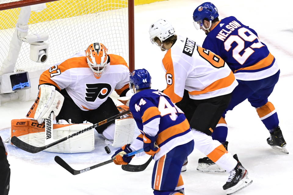 Philadelphia Flyers goaltender Brian Elliott (37) makes a save as Flyers defenseman Travis Sanheim (6) and New York Islanders center Jean-Gabriel Pageau (44) and Brock Nelson (29) battle for position during the first period of an NHL hockey second-round playoff series, Sunday, Aug. 30, 2020, in Toronto. (Frank Gunn/The Canadian Press via AP)