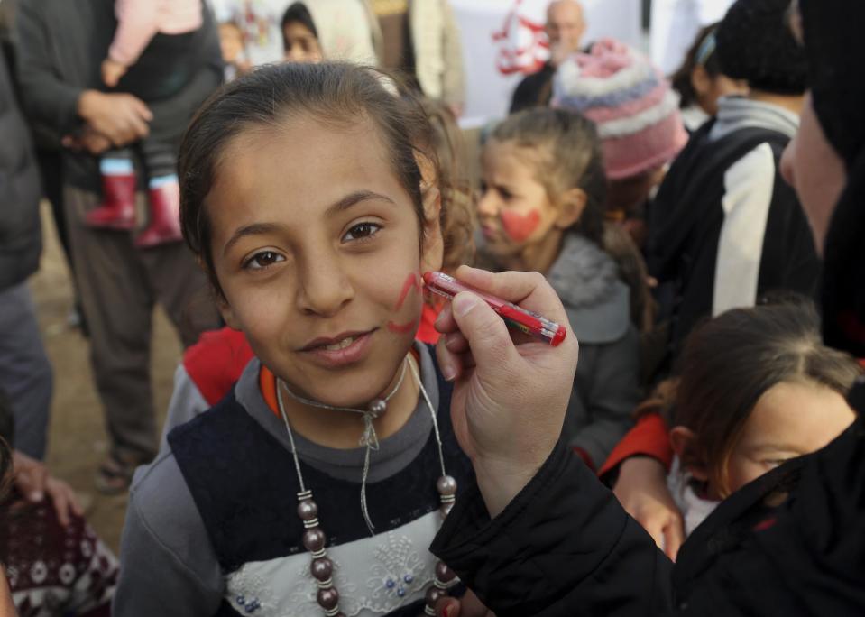 Iraqi internally displaced children having their faces painted during New Year's celebrations at the Hassan Sham camp, east of Mosul, Iraq, Saturday, Dec 31, 2016. (AP Photo/ Khalid Mohammed)