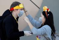 Visitors wearing protective face masks, following an outbreak of the coronavirus, are seen outside Tokyo Disneyland in Urayasu