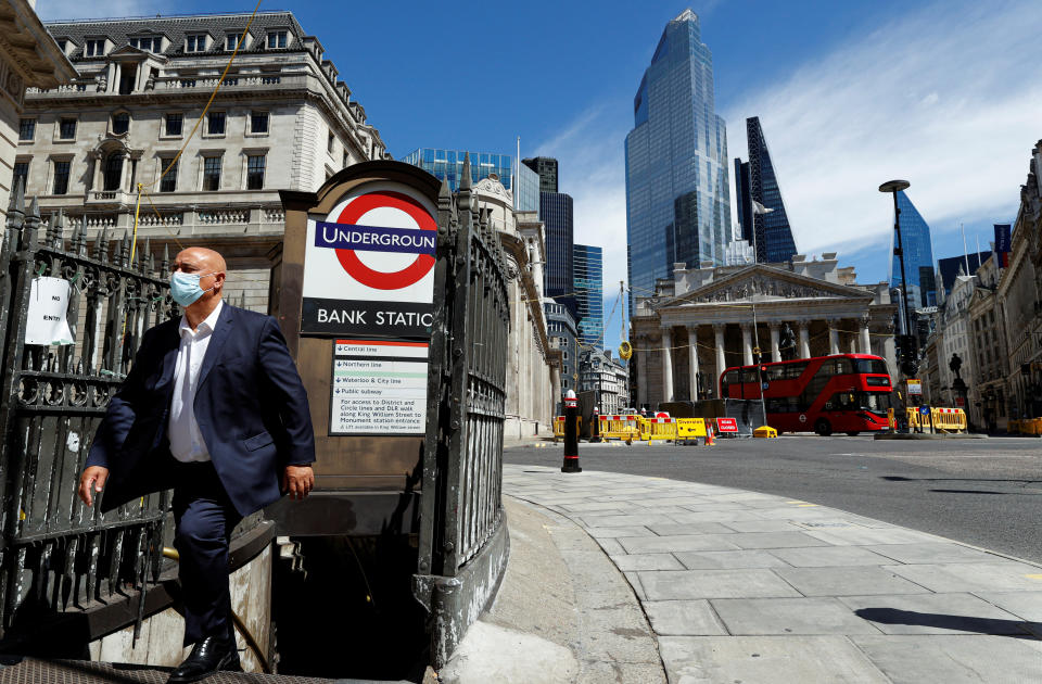 A man wearing a face mask and suit exits Bank underground station, in front of the Bank of England and Royal Exchange Building, amid the coronavirus disease (COVID-19) outbreak, in London, Britain, July 30, 2020.  REUTERS/John Sibley