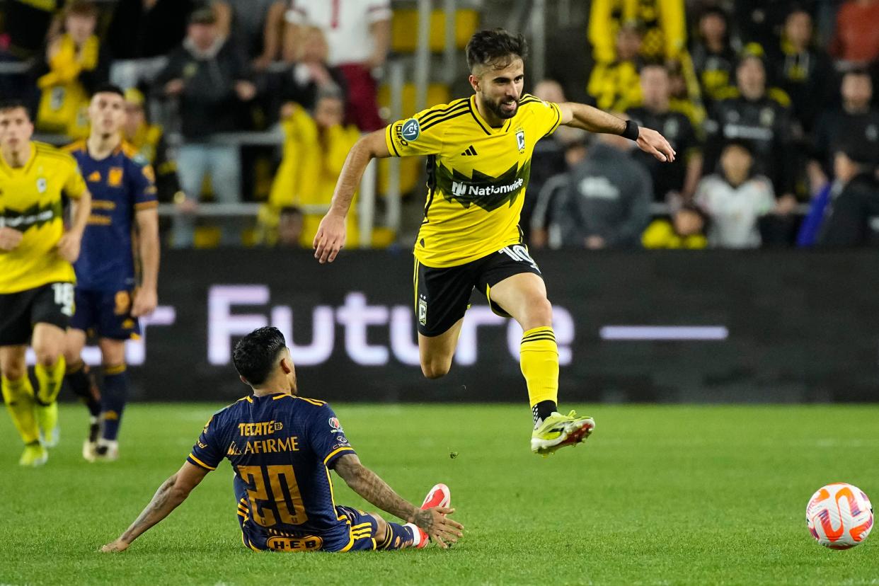 Crew forward Diego Rossi leaps over Tigres midfielder Javier Aquino during the second half of the Concacaf Champions Cup quarterfinal at Lower.com Field. The game ended in a 1-1 tie.