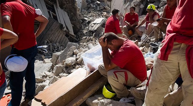 Rescuers pause in Amatrice, central Italy. Photo: AP/Emilio Fraile