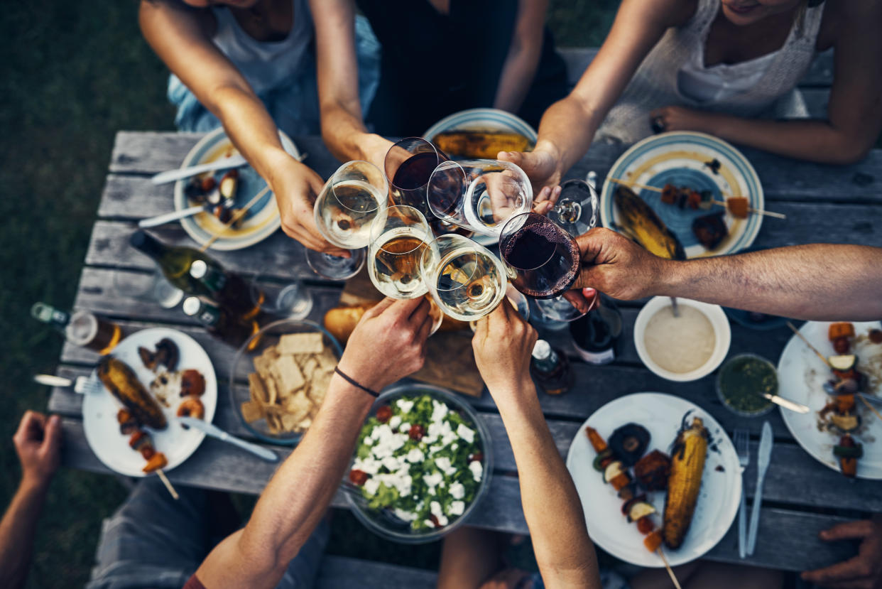 Shot of a group of friends making a toast over dinner