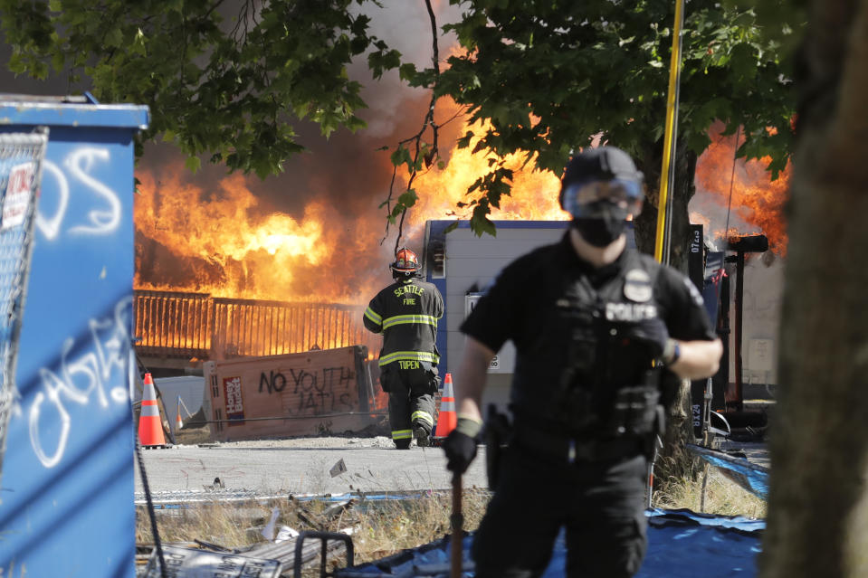 Construction buildings burn near the King County Juvenile Detention Center, Saturday, July 25, 2020, in Seattle, shortly after a group of protesters left the area. A large group of protesters were marching Saturday in Seattle in support of Black Lives Matter and against police brutality and racial injustice. Protesters broke windows and vandalized cars at the facility. (AP Photo/Ted S. Warren)