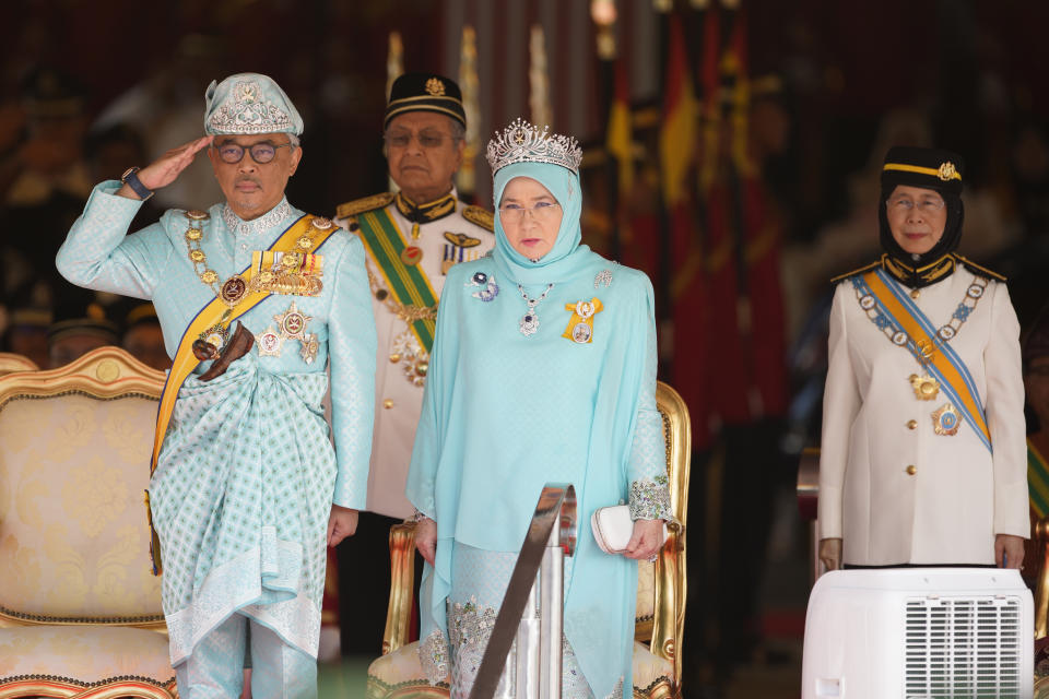 Malaysia's King Sultan Abdullah Sultan Ahmad Shah salutes next to Queen Tunku Azizah Aminah Maimunah, Prime Minister Mahathir Mohamad, second from left, and Deputy Prime Minister Wan Azizah Wan Ismail, right, during his welcome ceremony at Parliament House in Kuala Lumpur, Malaysia, Thursday, Jan. 31, 2019. Sultan Abdullah, ruler of central Pahang state, was named Malaysia's new king, replacing Sultan Muhammad V who abdicated unexpectedly after just two years on the throne. (AP Photo/Yam G-Jun)