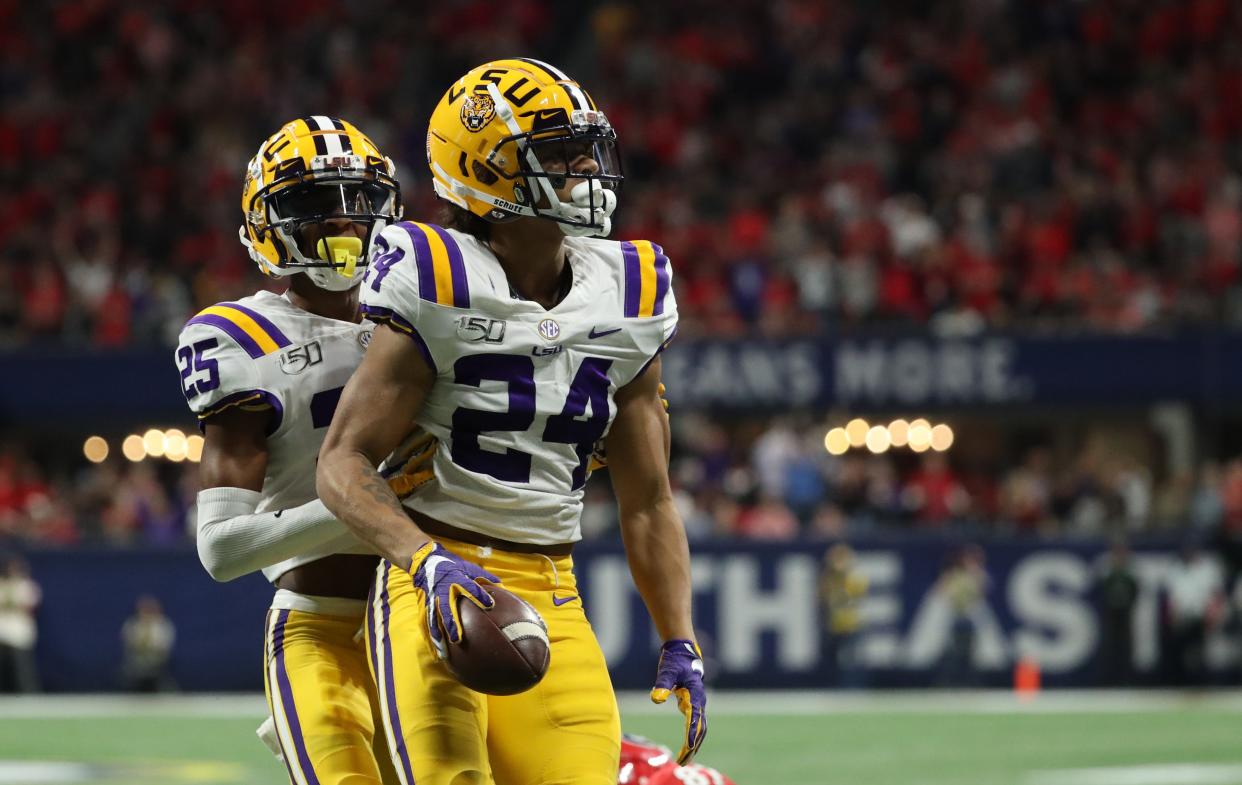 LSU cornerback Derek Stingley Jr. (24) celebrates an interception with cornerback Cordale Flott (25) in the second quarter against the Georgia Bulldogs in the 2019 SEC Championship Game at Mercedes-Benz Stadium.