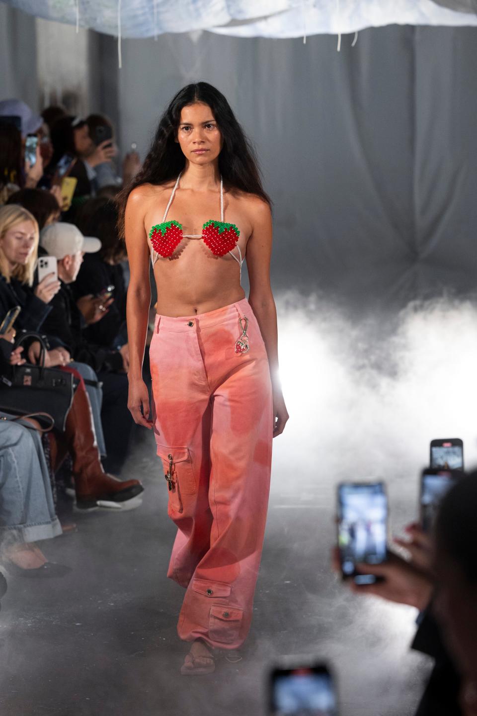 A model at the Helmstedt fashion show wearing a beaded strawberry bralette and pink denim jeans