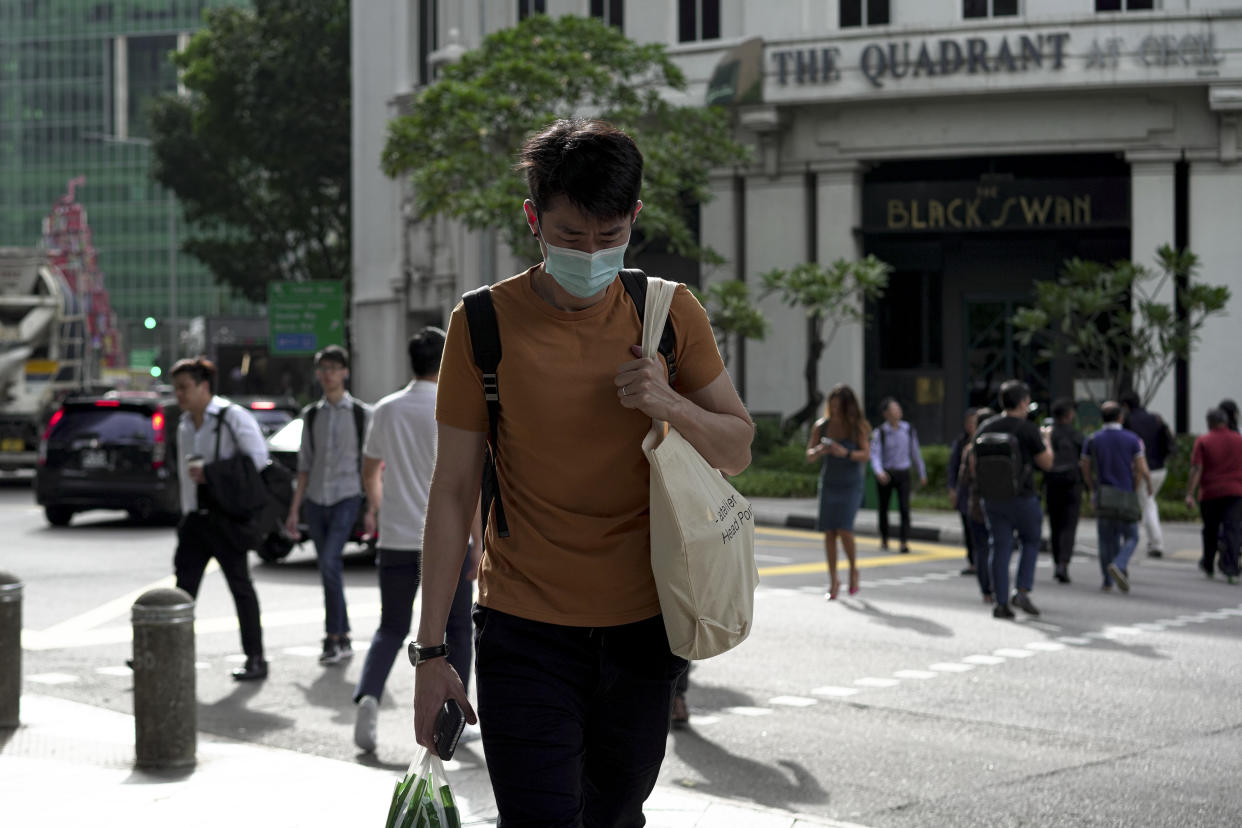 SINGAPORE, SINGAPORE - FEBRUARY 28: A man wearing a mask crosses the traffic junction at the Central Business District on February 28, 2020 in Singapore. The coronavirus, originating in Wuhan, China has spread to over 80,000 people globally, more than 50 countries have now been infected.  (Photo by Ore Huiying/Getty Images)