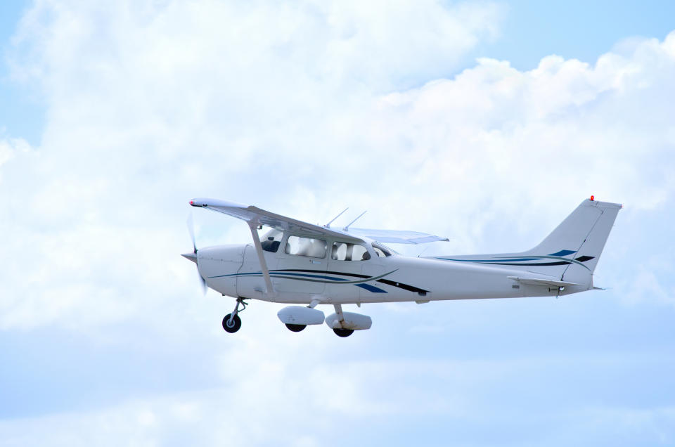 Single-engine airplane flying against a cloudy sky