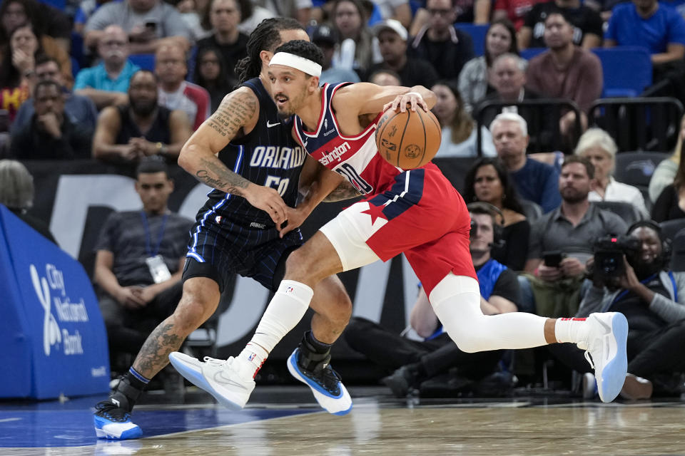 Washington Wizards guard Landry Shamet, right, drives to the basket against Orlando Magic guard Cole Anthony during the first half of an NBA basketball game Friday, Dec. 1, 2023, in Orlando, Fla. (AP Photo/John Raoux)
