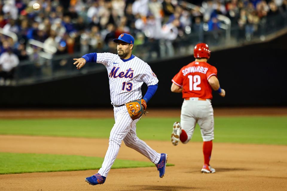 New York Mets shortstop Luis Guillorme (13) throws the ball to first base as Philadelphia Phillies designated hitter Kyle Schwarber (12) runs towards second base during the eighth inning of a baseball game, Sunday, May 1, 2022, in New York.