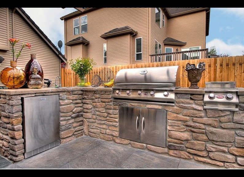 The beauty of an outdoor kitchen is it can be as simple or high-tech as you'd like. If you are working with a strict budget, then opt for a stainless steel table as an island next to your grill instead of installing a counter top. To add a sink or other appliance, you'll want a plumber or handy man to install a water line (for a dishwasher, hot water, and other needs). To save money you can choose a sink that connects to a garden hose, and chill drinks in an elevated tub or trough rather than a fridge. For shelter, you can install an overhang or simply purchase a tent. Finally, for grilling purposes, go as simple as a free-standing charcoal grill or have a large complete with stove top burners installed into the countertop area.     For a complete tutorial, visit <a href="http://www.thisoldhouse.com/toh/photos/0,,20489037_20949224,00.html" target="_hplink">This Old House</a>. 
