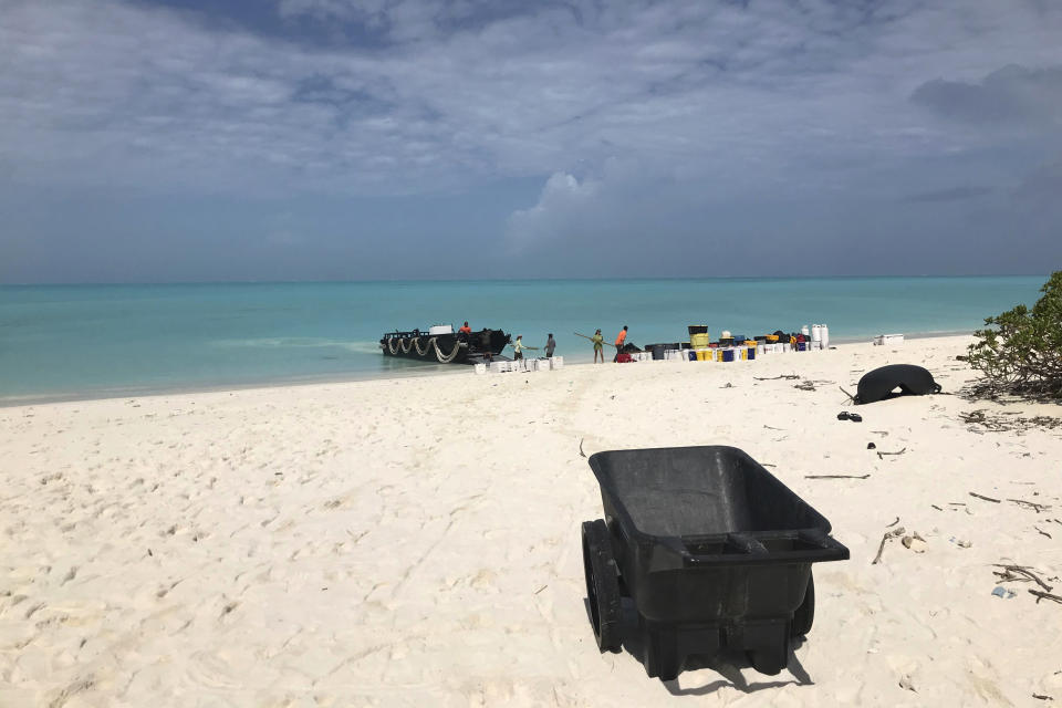 In this March 2, 2020, photo provided by Naomi Worcester, a crew of workers unload gear as they arrive on Kure Atoll in the Northwestern Hawaiian Islands, one of the most remote places on Earth. Cut off from the rest of the planet since February, four environmental field workers are back, re-emerging into a changed society by the coronavirus outbreak. (Naomi Worcester/Hawaii Department of Land and Natural Resources via AP)