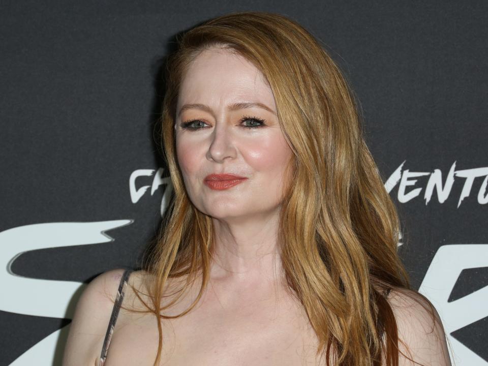 Miranda Otto standing in front of a black background