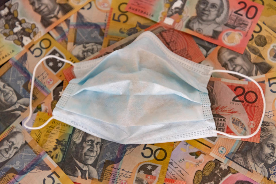 Illustration of a surgery mask and Australian dollar notes are seen displayed.