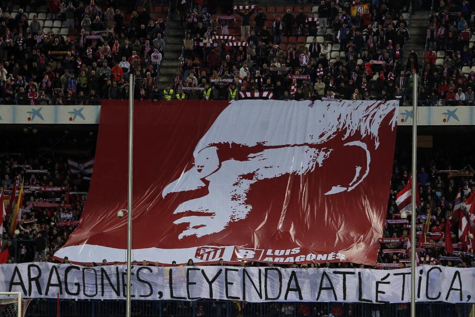 Atletico's fans display a flag reading "Aragones, Atletico's legend" with a picture of the late Luis Aragones, the former Spanish national coach, on it during a Spanish La Liga soccer match between Atletico de Madrid and Real Sociedad at the Vicente Calderon stadium in Madrid, Spain, Sunday, Feb. 2, 2014. (AP Photo/Andres Kudacki)