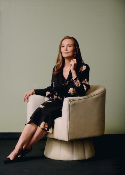 Diane Lane sits in a chair, posing, staring into the distance off camera