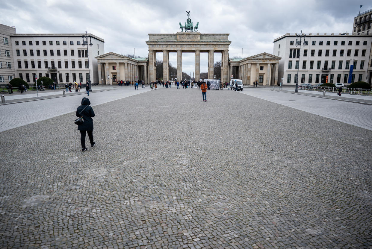 13 March 2020, Berlin: Only a few tourists stand on the Pariser Platz at the Brandenburg Gate. Photo: Michael Kappeler/dpa (Photo by Michael Kappeler/picture alliance via Getty Images)